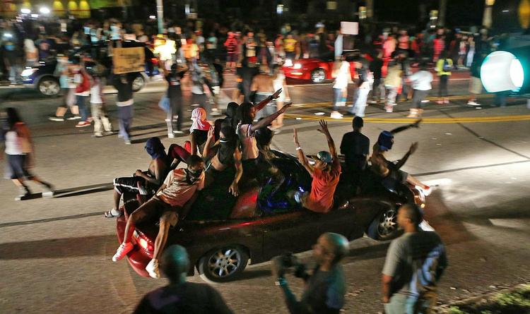 Uro. Maskerede mænd kørte torsdag igennem gaderne i Ferguson, der i flere dage har været ramme om store demonstrationer, men også plyndringer, efter at poltiet dræbte en teenager. 