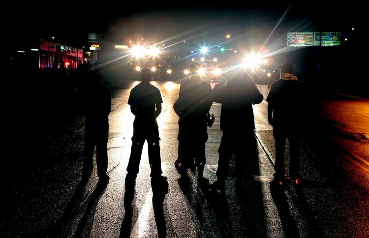 Uro. Politifolk ved en afspærring i Ferguson i går. Trods ordre om at rydde gaderne nægtede demonstranter at gå hjem. 