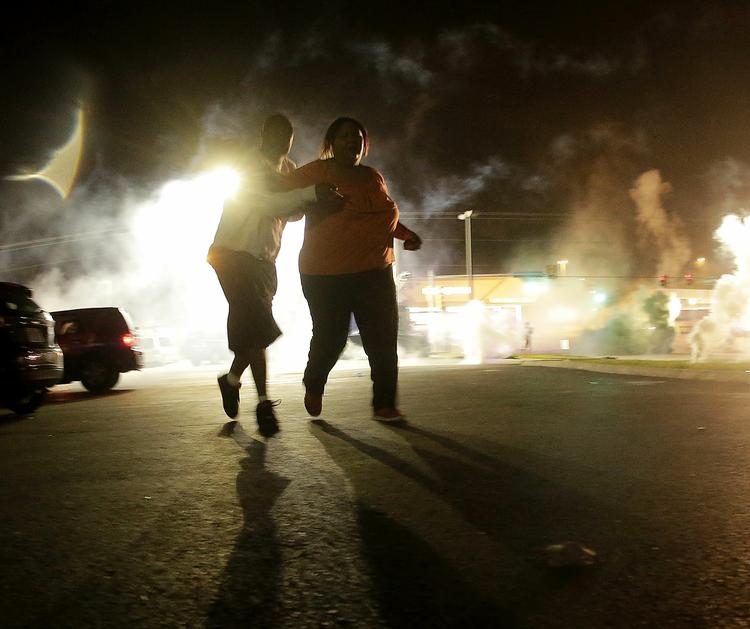 UROLIGHEDER. Beboere løber væk fra tåregassen under balladen i Ferguson søndag aften. 