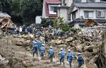 Skred. Redningsarbejdere gennemsøger boligområde i Hiroshima, der i nat dansk tid blev  ramt af et stort mudderskred. 