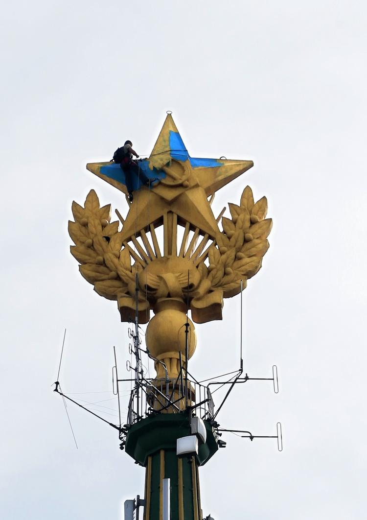 Krim. En arbejder er i gang med at overmale de blå-gule ukrainske farver på Kotelniki-skyskraberen i Moskva. 