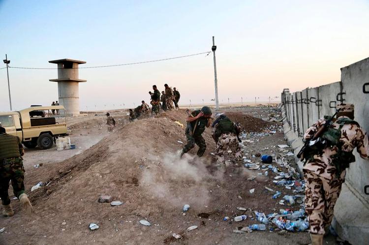 Frontlinjen. Kurdiske soldater uden for Erbil i det nordlige Irak søger dække, mens amerikanske kampfly hjælper med bombeangreb på Islamisk Stat. 