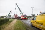 Trafikprop. En blokvogn med kran forsøger i dag at fjerne en havareret vindmølle fra en trafikeret rundkørsel i Ribe. 