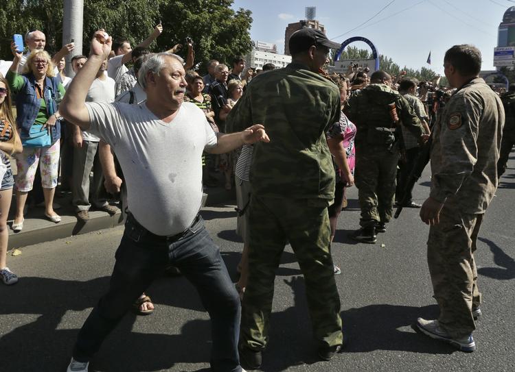 En mand kaster et æg mod de tilfangetagne ukrainske soldater i byen Donetsk. Soldaterne blev fulgt af rengøringsbiler, der symbolsk fejede gaden efter dem. 