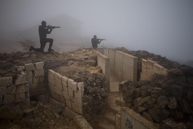 KONTROL. Bevæbnede mænd sidder på en gammel bunker på en udkigspost  Mt. Bental i det israelsk kontrollerede Golan med udsigt over grænsen til Syrien nær Quneitra provinsen. 