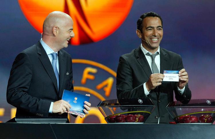 lodtrækning. Den tidligere franske topspiller Youri Djorkaeff (th.) har trukket FCK op af bowlen. Til venstre ses Uefas generalsekretær, Gianni Infantino. 