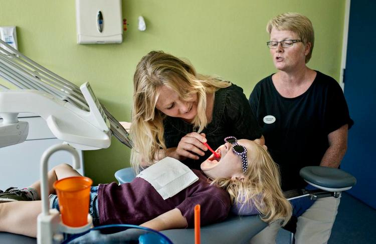 Børste-kursus. Det er lige så meget mor, der er til tandlæge, som det er Juliane. Klinikassistent Bonnie Nielsen lærer forældre, hvordan de standser karies med tandbørsten. 