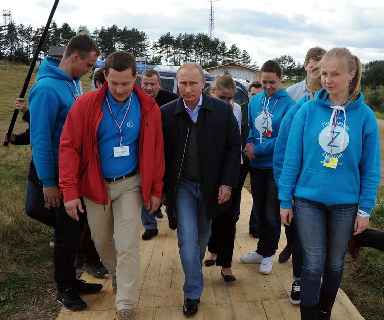 Besøg. Vladimir Putin går sammen med nogle af deltagerne på en lejr for unge. 