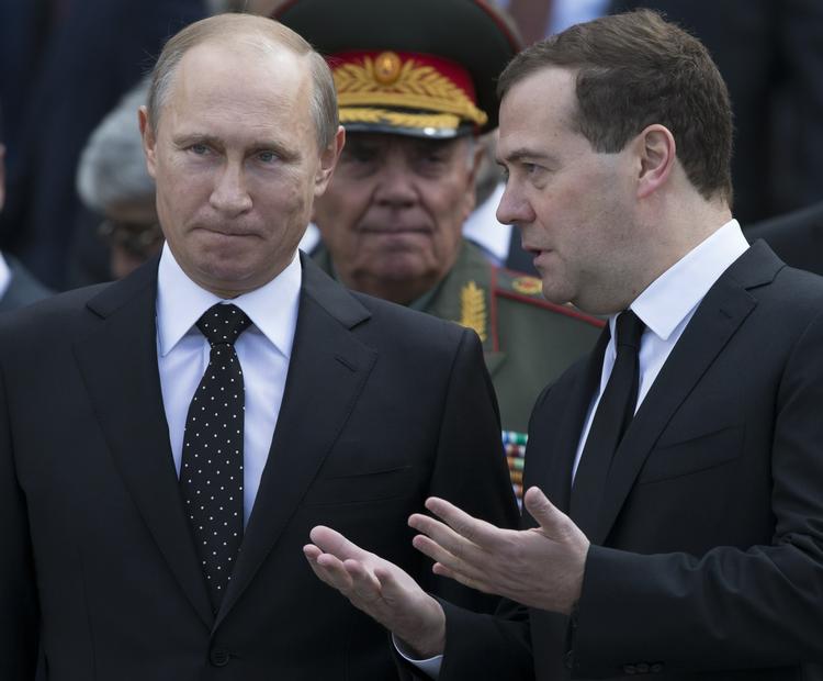 LEDERE. Her ses Dimitrij Medvedev (th) diskutere med præsident Vladimir Putin under en militærparade i Moskva. 