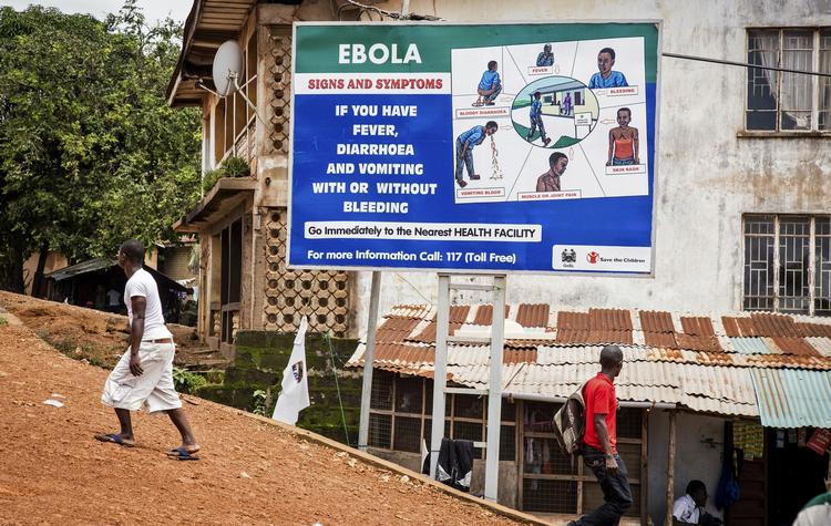 OPLYSNINGSKAMPAGNE. Kvinde passer informationsskilt om ebola i hovedstaden Freetown. 