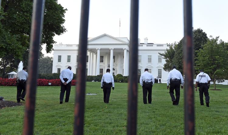 Tjek. Medlemmer af sikkerhedskorpset Secret Service undersøger plænen på nordsiden af Det Hvide Hus, efter at en mand fredag hoppede over hegnet og trængte ind i præsidentboligen. 