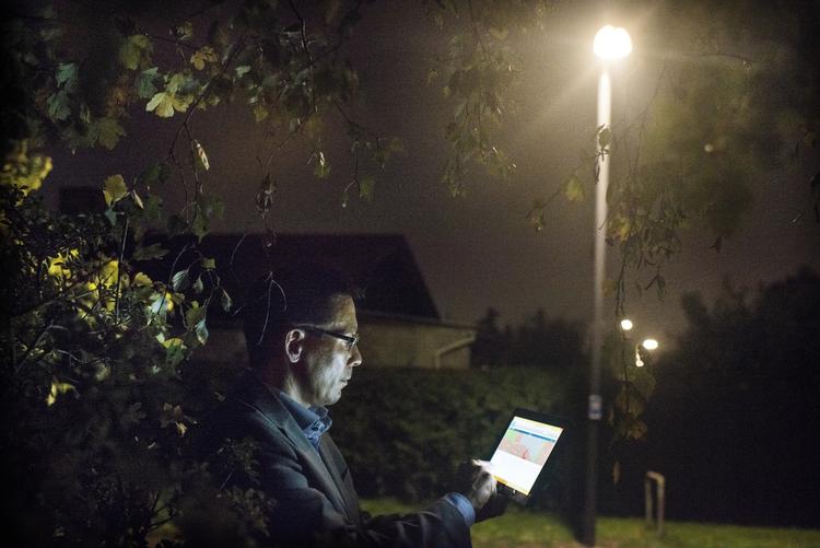 Styring.  Med en tablet i hånden kan Niels Levi styre de intelligente lygtepæle. Lygtepælen, han står under, er indstillet til at lyse på en bestemt måde, men kan også reguleres, hvis man ønsker meget eller lidt lys i en given periode. 