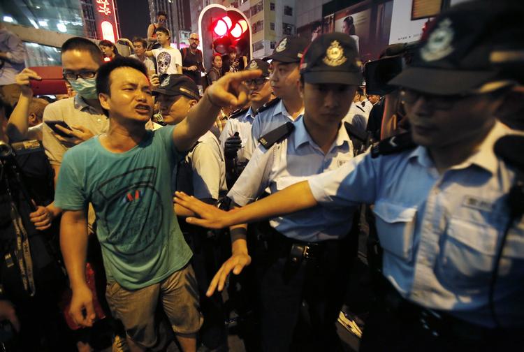 DEMONSTRATIONER. Politiet forsøger at skille prodemokratiske demonstranter og deres modstander i Mong Kok-distriktet i Hongkong. 