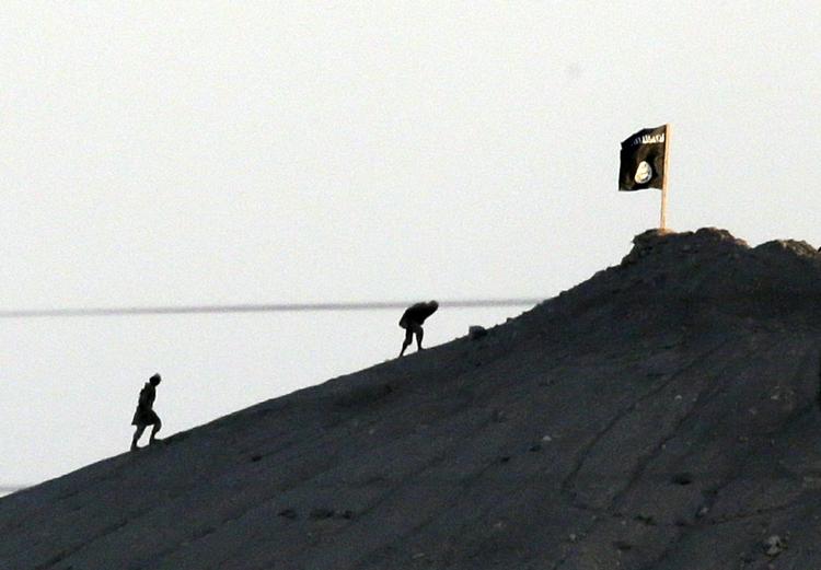 Kamp. Billedet er taget fra den tyrkisk-syriske grænse med et teleobjektiv, og det viser angiveligt militante oprørere fra Islamisk Stat, efter at de har placeret deres sorte flag på toppen af et bjerg øst for Kobani. Hvis IS indtager byen, kan det udvikle sig til en regulær massakre på den kurdiske befolkning i byen. 