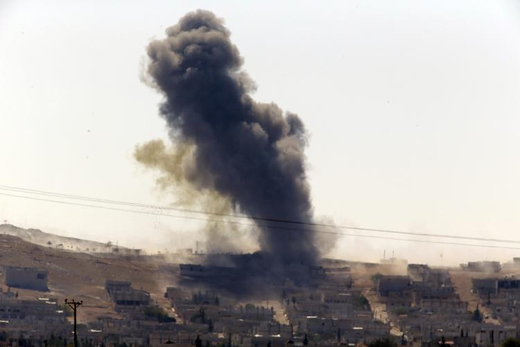 kamp. Røgen stiger til vejrs over Kobani i Syrien. Billedet er fra i går. Islamisk Stat har indtaget tre distrikter i den afgørende grænseby til Tyrkiet. 