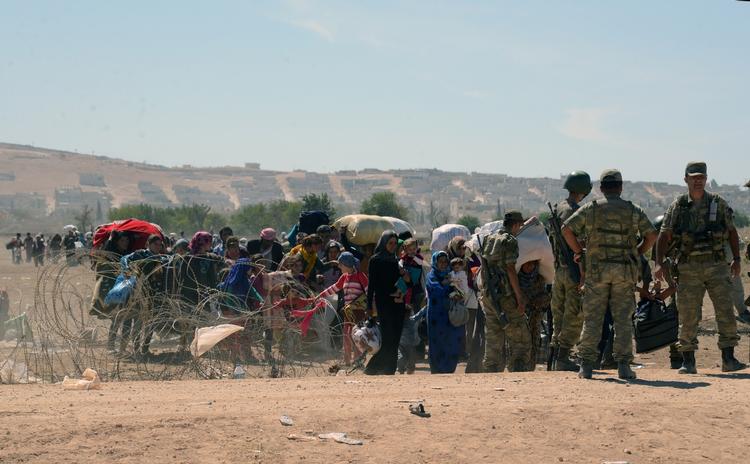 Asyl. Kurdiske flygtninge forlader det borgerkrigsramte Syrien og bevogtes af tyrkiske soldater, da de krydser grænsen ind til Tyrkiet ved Suruc. Herhjemme mener DF og LA, at asylansøgere til Danmark skal placeres i danske lejre i deres nærområde. 