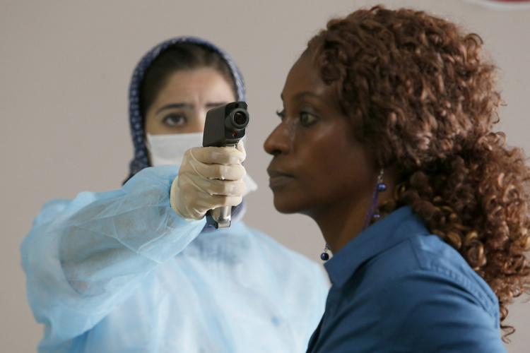 ebola. Marrokansk sundhedspersonale screener passagerer med et termometer ved ankomsten til lufthavnen i Casablanca. Myndighederne i landet håber, at de på den måde kan hindre eventuelle ebolasmittede, der udviser symptomer, i at rejse videre. 