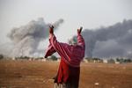 Belejring. En syrisk kurder, den 56-årige Kiymet Ergun, jubler ved grænsen mellem Tyrkiet og Syrien over et USA-ledet bombardement af Islamisk Stats stillinger ved Kobane. 