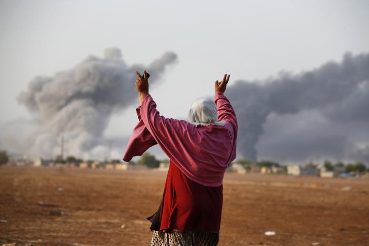 Belejring. En syrisk kurder, den 56-årige Kiymet Ergun, jubler ved grænsen mellem Tyrkiet og Syrien over et USA-ledet bombardement af Islamisk Stats stillinger ved Kobane. 