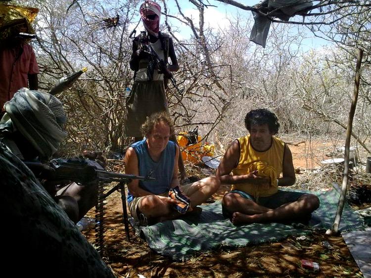 Pression.Piraterne tog jævnligt billeder af deres gidsler. Billederne blev sendt hjem til familierne som pression. Her sidder Søren Lyngbjørn og Eddy Lopez en måned efter kapringen med hænderne bundet ind. Piraterne havde bildt familierne ind, at deres negle var revet af, hvad de ikke var. 