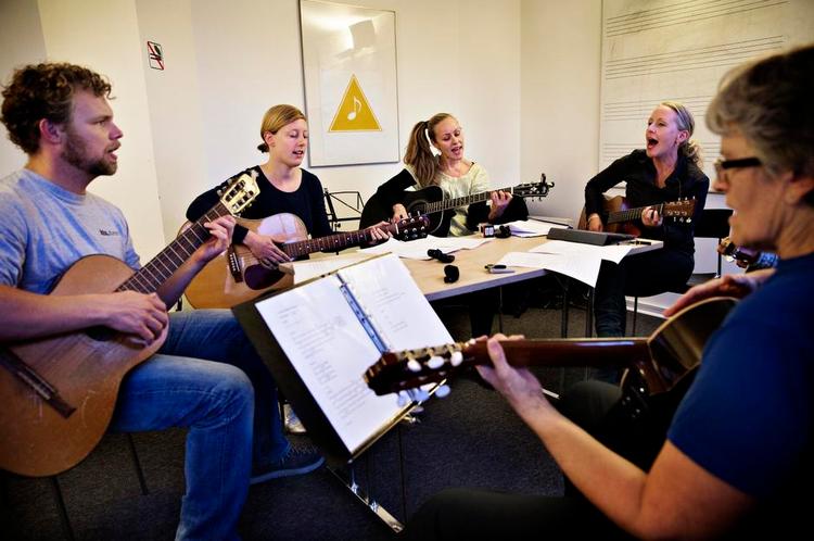 ENERGI. Der bliver kun sunget og spillet hver 14. dag på guitarholdet her med Mette Lethan som underviser. Aftenskolerne har været nødt til at ændre deres kurser, fordi folk har svært ved at få en ugentlig aftenskole til at passe ind i deres liv. 