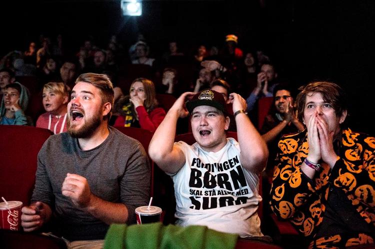 De tre jublende er fra venstre: Andreas “ironshaft” Thomsen, Lars (med kasket), og Lars Boe Der er finalen i verdens største e-sport, League of Legends, og det er noget spilfolket dyrker akkurat ligesom fodboldfans ser champions league. VM-finalerne finder sted i Sydkorea, men bliver transmitteret via internettet og bliver altså vist i Valby Kino, hvis tre sale er udsolgte. Kort sagt: Nørder, computersport og god stemning. 