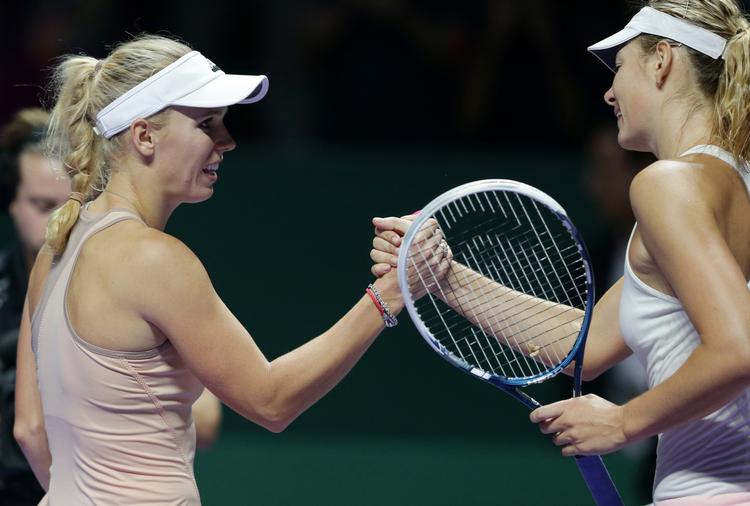 fysisk. Caroline Wozniacki (tv) siger tak for kampen til verdens nummer to, Maria Sharapova. 