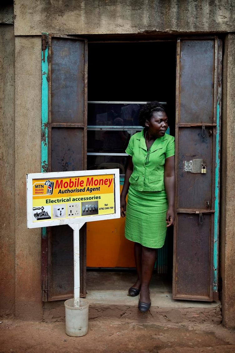 Mobilmoneter. Esther, som Politiken har fulgt i snart 11 år, har en indtægt - hun får løn for at flytte penge via mobil telefon for beboerne i sit slumkvarter i Kampala i Uganda. Arkivfoto: Finn Frandsen 