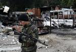granatnedslag. En pro-russisk militssoldat et ødelagt autoværksted i byen Donetsk i september. Nu er byen under Ukrainske troppers kontrol, men konflikten har medført mange flygtninge. 