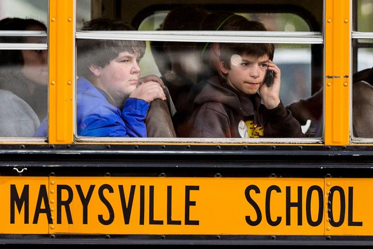 En drenge forsøger at ringe, mens han bliver kørt til et samlingssted efter skyderiet på Marysville Pilchuck High School i Marysville, Washington. 