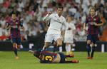 TACKLING. Real Madrid's Cristiano Ronaldo bliver her tacklet af Barceona's Gerard Pique i aftenens kamp. 
