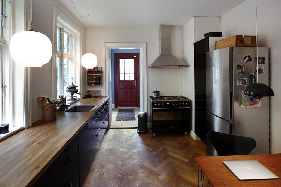 Nyt gammelt gulv. Køkkenet har som de fleste andre rum i huset været endevendt fra A til Z. En utæt håndvask hos de forrige ejere betød et råddent gulv, der siden er fjernet sammen med 3 lag linoleum. Det nye sildebensparket har Henrik lagt i genbrugsparket fra Østtyskland fundet hos Genbyg.dk, mens køkkenelementerne er fra Ikea og tilsat købmandsgreb. I vindueskarmen står selvfølgelig en russisk samovar fundet på et loppemarked. 