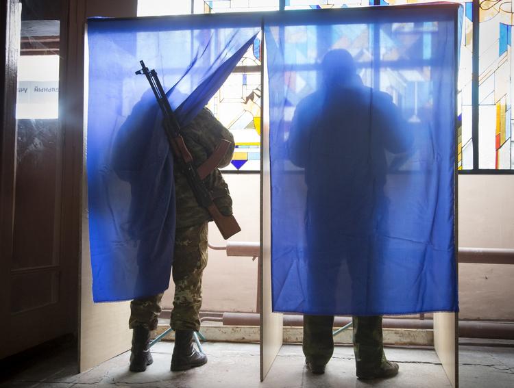 valg. Prorussiske oprørere afgiver deres stemme ved et valgsted i en af separatisternes militærbaser i Donetsk i dag. 