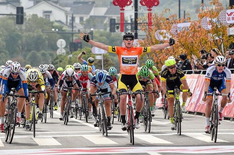 opløb. Australieren Sam Witmitz jubler over sin tredje etapesejr i Tour of Taihu Lake, mens danskeren Søren Kragh og Patrick Clausen i hver sin side af vejen bliver henholdsvis nr. 2 og 4. 