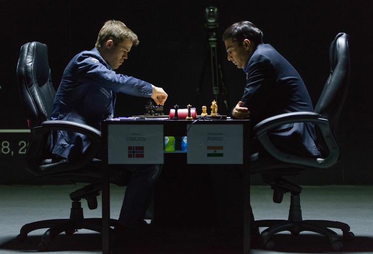 remis. Norges verdensmester Magnus Carlsen (tv) foretager et træk i VM-kampen mod den tidligere verdensmester fra Indien, Vishwanathan Anand. 