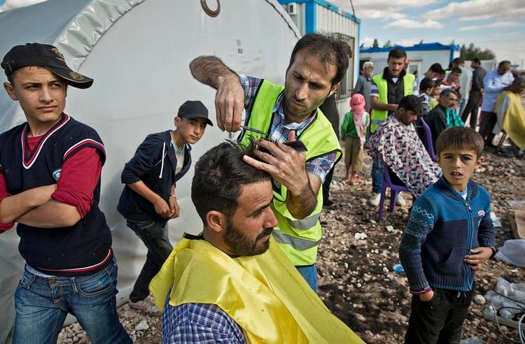 Asyltal. Flygtningene strømmer ud ud af Syrien. Her får et par flygtninge lokkerne trimmet i en flygtningelejr i Suruc i Tyrkiet nær Kobane i Syrien. FOTO: AP 
