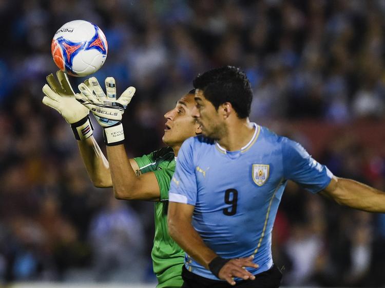 clasico. Costa Ricas goalkeeper Keylor Navas, som spiller for Real Madrid, griber bolden foran næsen på Uruguays Luiz Suarez, der spiller for Barcelona. 