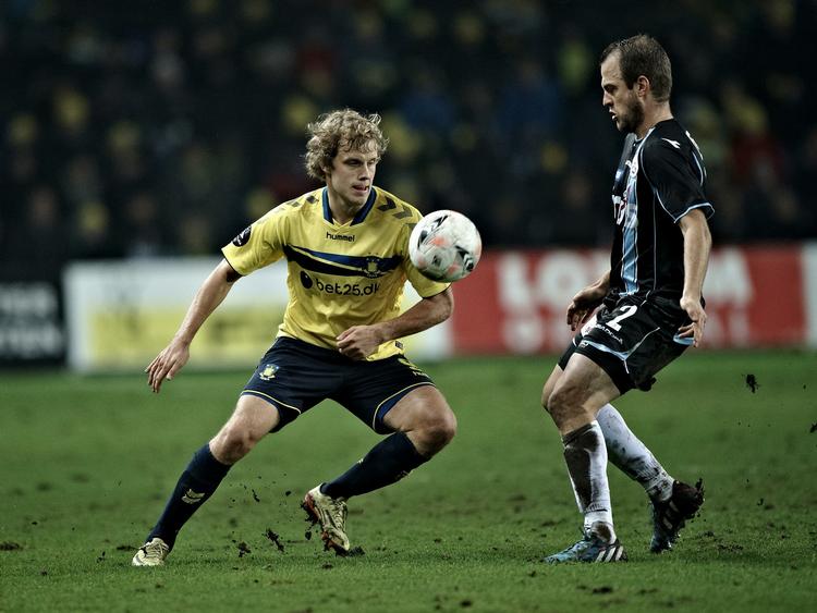 Pløjemark.  Teemu Pukki  prøver at få kontrol over bolden, mens græstotter flyver til højre og venstre. 