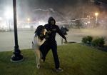 Uro. Demonstranter flygter fra politiets  tåregasgranater i Ferguson, efter at en afgørelse i sagen om en betjents drab på en 18-årig ubevæbnet mand skabte gadeprotester. 