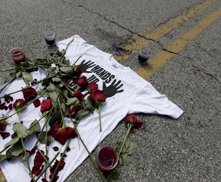 KONGRONTATION. Blomster og en t-shirt lå efter drabet på Michael Brown midt på Canfield Drive i Ferguson som et minde om det blodige møde. 