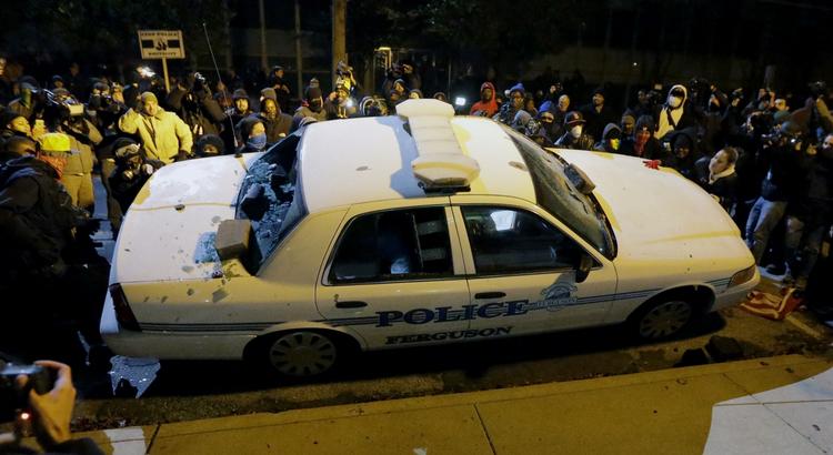 ØDELÆGGELSER. Demonstranter vælter politibil i Ferguson. 