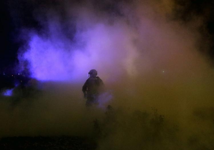OPTØJER. Betjent indhyllet i røg nær rådhuset i Ferguson under nattens uroligheder. 