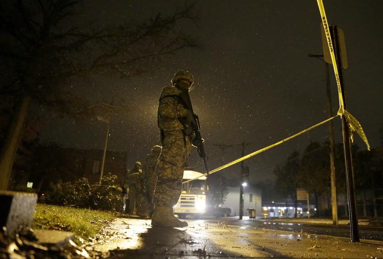 Vrede. Et medlem af Missouris hjemmeværn står vagt foran rådhuset i Ferguson. Politiet efterforsker mistanke mod to mænd, der angiveligt ville myrde anklageren i St. Louis på grund af sagen. 