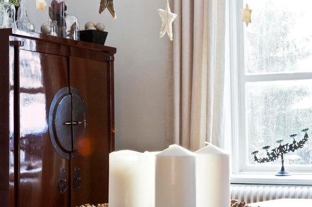 Krans. Adventskransen på spisebordet er en oasiskrans med kogler, der er sat i med blomstertråd. Fra lysekronen hænger stjerner i hvidt, sølv og guld i tynde sytråde sammen med kogler fundet i skoven. 
