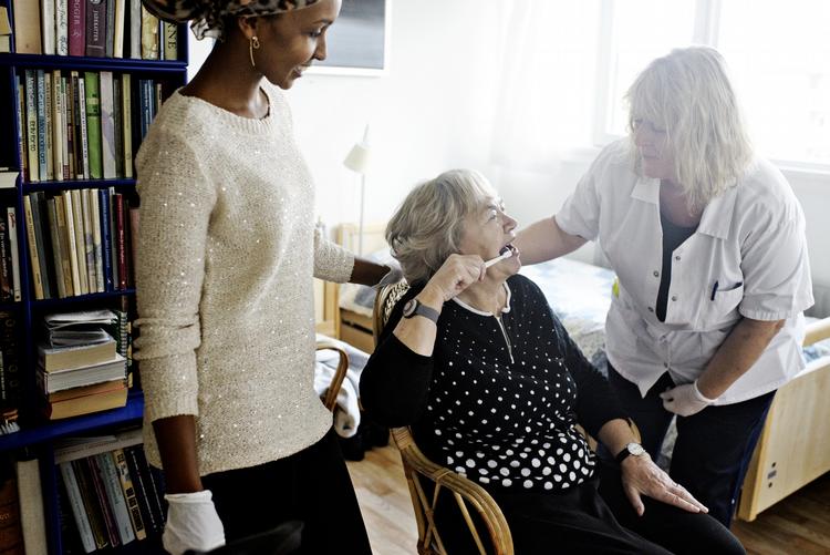 Kontrol. Beboer Hanne Beck klarer selv tandbørstningen, men er glad for, at klinikassistent Jette Johansen (th.) tjekker efter. Plejeassistent  Farhiya Abdiaziz (tv.) bliver samtidig oplært i at se efter, om beboernes tænder og mund er rene her på Peder Lykke Centret på Amager. 