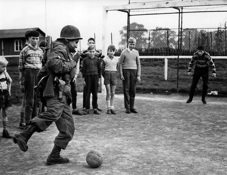 Legetime. Amerikansk G.I. spiller fodbold med lokale tyske drenge i 1960'erne. 