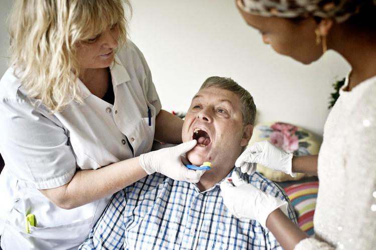 Mundpleje. Beboer Svend Åge Christensen får undersøgt tænderne af klinikassistent Jette Johansen (tv.), som kommer fast på Peder Lykke Centret på Amager hver 3. uge. Plejehjemsassistent  Farhiya Abdiaziz assisterer. 