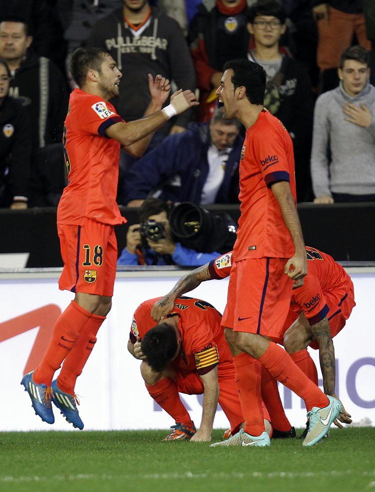 advarsel. De fleste opdagede ikke, at Lionel Messi (bagerst i midten) fik en fyldt vandflaske i hovedet, da Barcelona fejrede scoringen mod Valencia. 