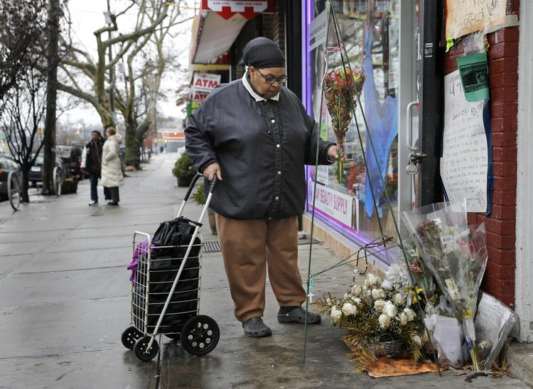 USA. En kvinde lægger blomster ved det sted i Staten Island, hvor Eric Garner blev dræbt af politiet. 