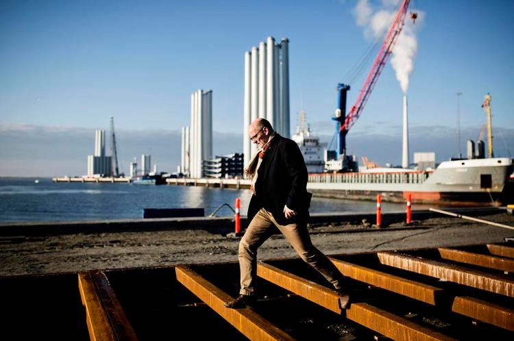 BALANCE. Esbjerg er Europas suverænt største havn på havvind og Danmarks centrum for offshore olie og gas. Havnedirektør Ole Ingrisch med havvindmølletårne i baggrunden balancerer konstant mellem ønsket om vækst i omsætning og investeringer i milliardklassen. Indtil videre med held. Foto: Line Ørnes Søndergaard 